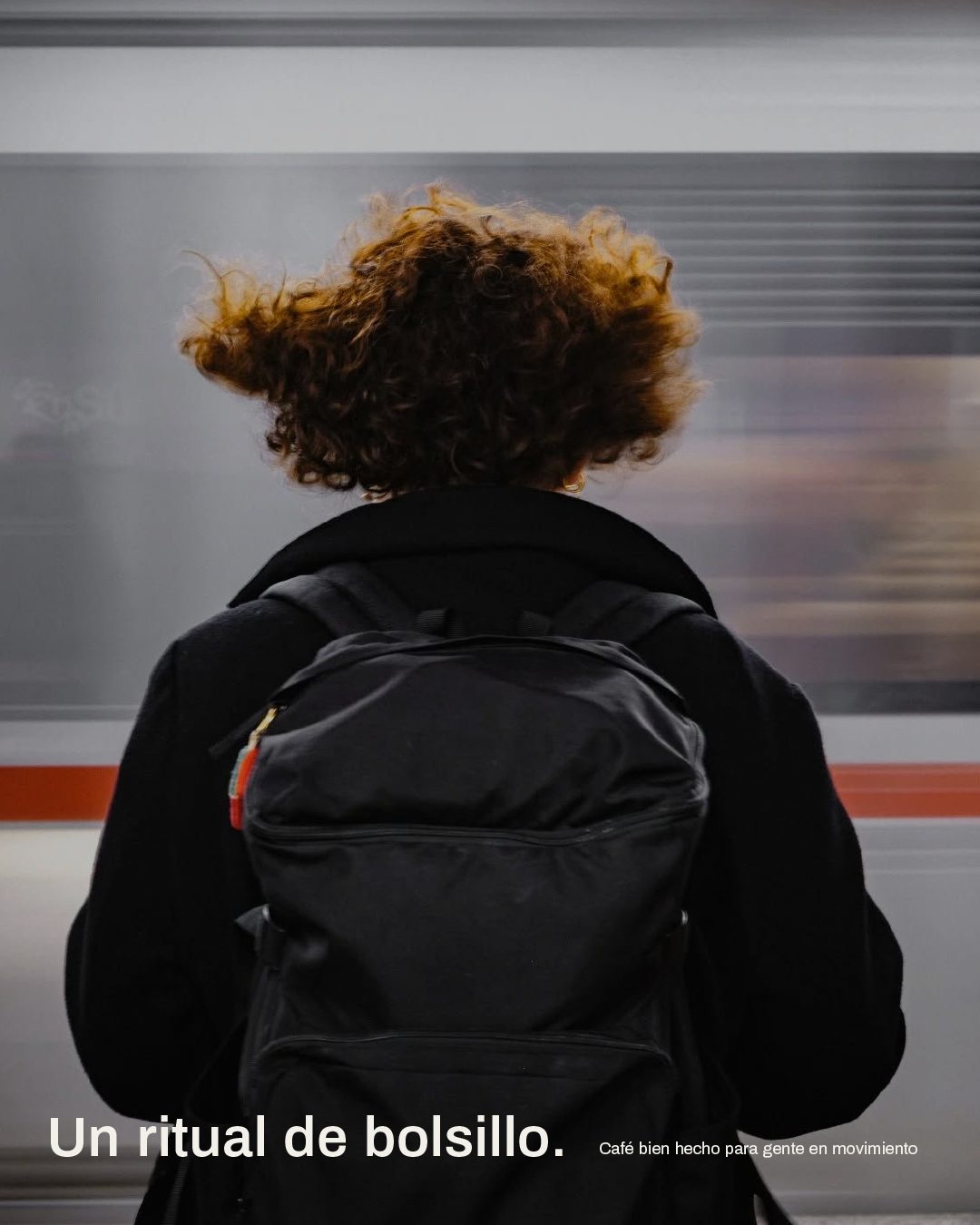 Persona esperando el tren con una mochila